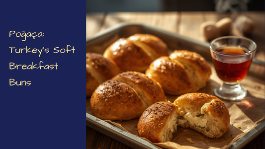 Golden cheese-filled poğaça buns sprinkled with nigella seeds on a plate beside a glass of Turkish tea