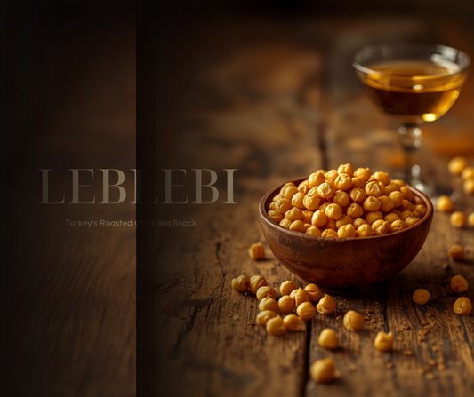 Bowl of pale golden roasted Turkish chickpeas (leblebi) beside a tulip tea glass on a wooden table